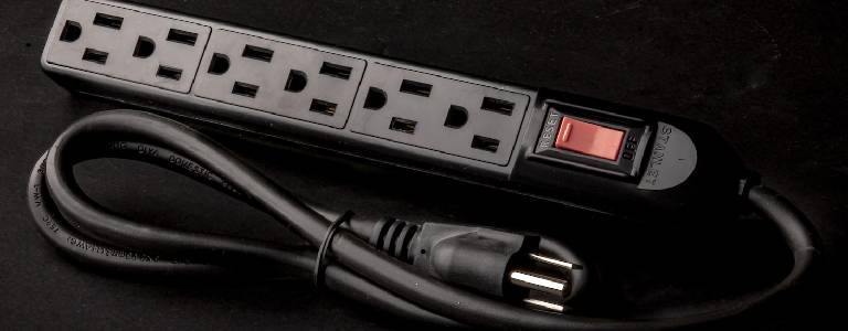 Black extension cord on a black background.