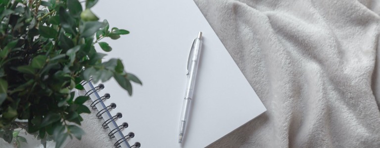 Blank white notebook with pen