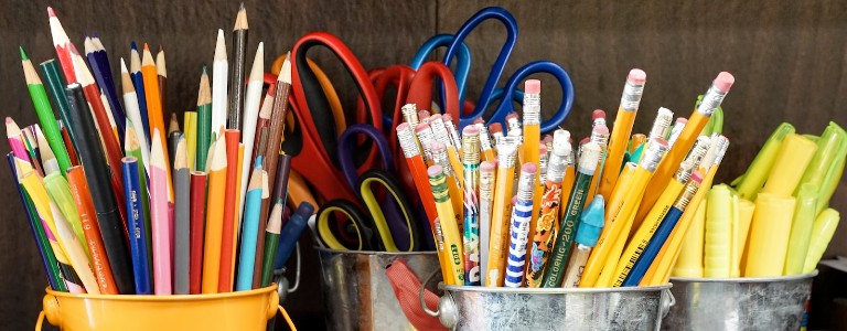Buckets of color pencils, scissors, pencils and highlighters
