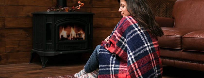 Woman sitting by cozy fireplace at home